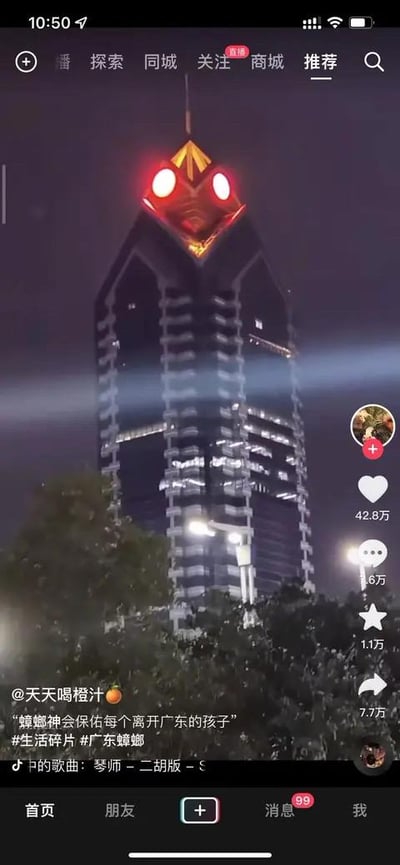 这是一张抖音平台的视频截图，画面主体是夜晚的广州某地标建筑，其顶部的红色灯光与建筑造型结合，视觉效果神似蟑螂的头部与眼睛。视频配文“蟑螂神会保佑每个离开广东的孩子”，结合广东地区蟑螂体型大、存在感强的地域特点，玩起了搞笑关联梗，调侃离开广东的人仿佛能得到“蟑螂神”的特殊“庇佑”，戳中网友笑点。截图显示该视频获得42.8万点赞、6万条评论、1.1万次收藏和7.7万次转发，互动数据亮眼。