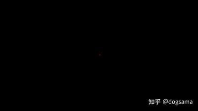 整张图以纯黑色为背景，画面中心偏上的位置有一个极小的红色光点，在深色背景的衬托下成为唯一的视觉焦点，右下角带有知乎用户@dogsama的水印，画面风格极简，没有其他多余元素，给人一种静谧、孤独的视觉感受。
