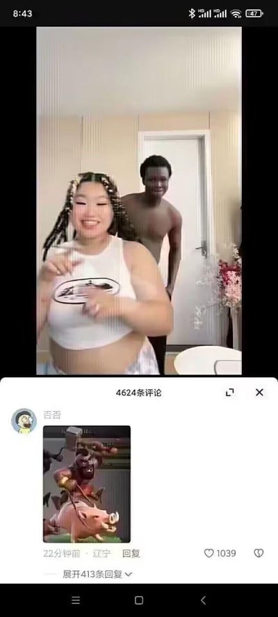 这是一张短视频平台的截图，画面分为上下两部分：上方是短视频内容，一位编着脏辫的女生开心地对着镜头做手势，脸上带着大笑的表情，她身后站着一位赤裸上身的黑人男性，面带微笑；下方是该视频的评论区，用户“否否”发布了一张手游《部落冲突》中野猪骑士的游戏截图，用这个兵种形象来对应视频里的两人组合，玩梗调侃，这条评论发布于22分钟前，地址显示辽宁，获得了1039个点赞，还有413条回复，整体氛围充满搞笑的调侃意味。