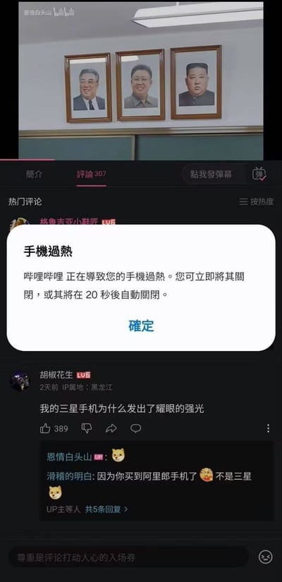 这是一张B站手机端的界面截图，上方为正在播放的视频界面，中间弹出手机系统提示框，提示哔哩哔哩正在导致手机过热，可选择立即关闭或等待20秒后自动关闭；下方是该视频的热门评论区，有用户留言调侃自己的三星手机发出强光，其他用户回复玩梗称他买到的不是三星手机，结合三星手机过往曾出现的电池过热爆炸相关公共事件形成笑点。
