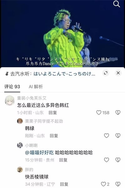 这张截图的上半部分是演出现场画面，一名戴着眼镜、染着亮绿色头发、身穿荧光绿外套的男歌手正手持话筒在舞台上演唱，画面配有日语和中文双语歌词；截图下半部分是该内容的抖音平台评论区，最高赞评论调侃“怎么最近这么多异色韩红”，下方有网友紧跟玩谐音梗回复“韩绿”，还有其他网友的互动评论，整体是围绕歌手外形撞脸韩红衍生的趣味玩梗内容。