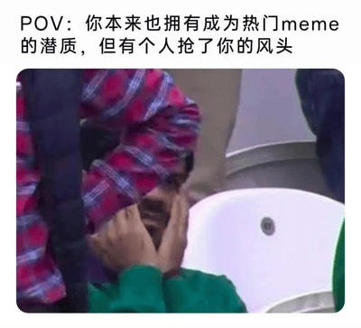 图片上方配有文字“POV：你本来也拥有成为热门meme的潜质，但有个人抢了你的风头”，下方是一张真人场景截图。图中人物穿着绿色上衣，头上裹着红蓝色格子毯子，双手捂脸，身处有白色座椅的场所（疑似体育场或大型活动现场），表情透露出无奈与尴尬，整体营造出一种“本有机会走红却被他人抢占先机”的幽默自嘲氛围。