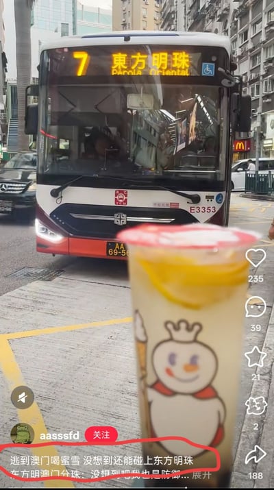 图片展示了澳门街头场景，前景是一杯印有蜜雪冰城雪王形象的奶茶，杯身有黄色柠檬片装饰。背景中一辆7路公交车正行驶而来，车头电子屏显示目的地为“东方明珠”。图片下方有用户评论“逃到澳门喝蜜雪 没想到还能碰上东方明珠”，并配有回复“东方明珠澳门分珠：没想到吧我也是防御...”，通过将上海地标“东方明珠”与澳门公交车目的地幽默关联，制造出意外巧合的搞笑效果。