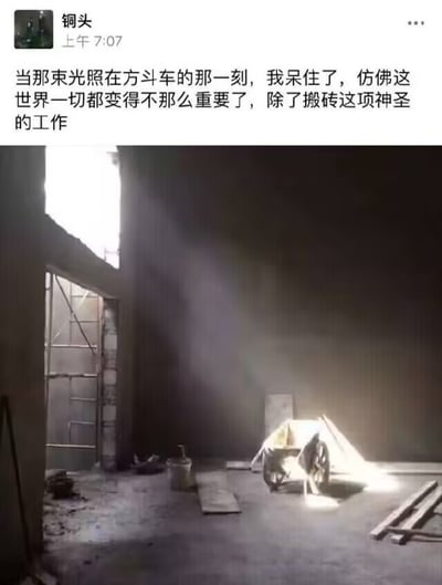 社交媒体截图，上方是用户“铜头”发布的文字内容：“当那束光照在方斗车的那一刻，我呆住了，仿佛这世界一切都变得不那么重要了，除了搬砖这项神圣的工作”。下方配图为工地内部场景，一束强光从上方照射在地面的方斗车上，周围环境昏暗，可见脚手架、水桶和木板等施工工具，营造出一种戏剧性的光影效果，与文字内容形成幽默反差。