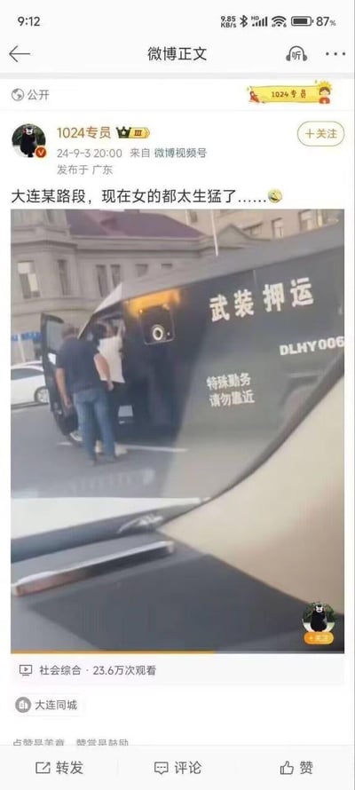 这是一张微博视频的截图，画面呈现大连某路段的街头场景：一辆印有“武装押运”“特殊勤务 请勿靠近”及编号“DLHY006”的黑色押运车停在路边，一名女子正和押运车的工作人员在车门处近距离互动。微博配文调侃“现在女的都太生猛了……”，并搭配了一个哭笑不得的表情。该视频属于社会综合类内容，已有23.6万次观看，还添加了“大连同城”标签，引发网友对该女子行为的讨论。