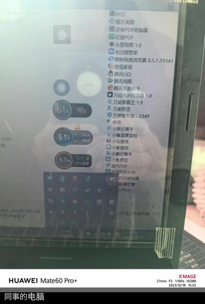 这是一张使用华为Mate60 Pro+拍摄的同事的电脑屏幕照片，屏幕显示Windows系统的开始菜单，里面罗列了超过30款各类软件，涵盖PDF处理、影音播放、社交聊天、系统工具等多个类别；桌面同时显示三个悬浮监控组件，分别呈现网络连接状态、实时网速、CPU温度与电量情况，底部任务栏可见部分图标。图片底部带有华为Mate60 Pro+的拍摄标识与参数，标注拍摄时间为2023年12月18日15:52，下方还有“同事的电脑”的文字说明。