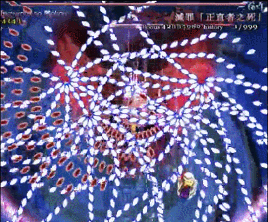 这是一段东方Project系列弹幕射击游戏的动态画面，画面中布满了密密麻麻、呈放射状与环状交织的各色弹幕，玩家操控的小型角色在密集的弹幕缝隙中灵活移动躲避，极致的弹幕密度展现出这类“弹幕地狱”游戏的超高难度，动态的弹幕流动让画面充满了紧张的压迫感，十分考验玩家的反应力与操作精度。