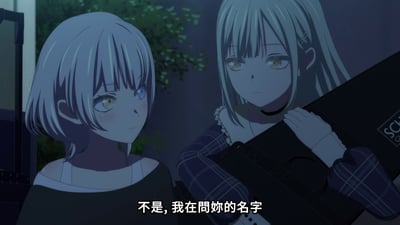 图片展示了动漫《MyGO!》中的两个女性角色场景。左侧角色为短发银灰色头发，蓝色眼眸，脸颊略带红晕，表情略显羞涩，身穿深色上衣；右侧角色为长发银灰色头发，黄色眼眸，表情平静，身穿格子外套，手持一个黑色的物品（疑似乐器盒）。背景为夜晚户外场景，有绿色植物点缀。画面底部有白色字幕：“不是，我在問妳的名字”，显示角色间正在进行对话。