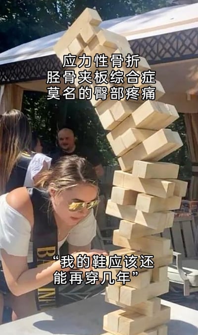 这是一张静态真人场景的搞笑梗图，画面呈现的是户外聚会场景，一位戴着墨镜的女性正专注操作大型叠叠乐，此时叠叠乐已经严重倾斜，处于即将崩塌的状态。图片上方标注了“应力性骨折、胫骨夹板综合症、莫名的臀部疼痛”这些运动损伤症状，下方则是“我的鞋应该还能再穿几年”的文字，用叠叠乐即将倒塌的危机状态，类比因舍不得更换旧鞋，长期穿着不合适的鞋子运动而引发多种身体损伤的情况，以夸张幽默的方式调侃了生活中因吝啬旧物反而引发问题的行为，充满生活趣味。