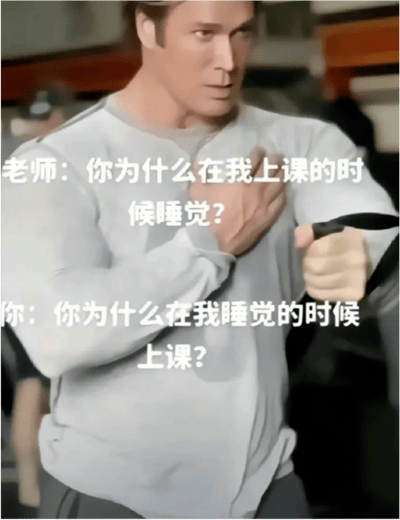 图片中是美国健身网红迈克·奥赫恩，他身着灰色长袖上衣，手持黑色健身带，单手置于胸前，表情呈现出“大力王”梗标志性的迷之自信。画面叠加了两组对话文字：上方为“老师：你为什么在我上课的时候睡觉？”，下方为“你：你为什么在我睡觉的时候上课？”。通过这种将责任反向归因的无逻辑对话，生动展现了“大力王文学”讽刺盲目自信的核心特质，成为年轻人用于调侃和情绪宣泄的搞笑梗图。