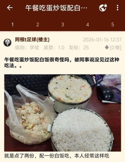 社交媒体帖子截图，用户“阿根t足球”分享自己的午餐——一份蛋炒饭和一份白饭，并配文提问“午餐吃蛋炒饭配白饭很奇怪吗，被同事说没见过这种吃法。。”，下方补充说明“就是点了两份，配一份白饭吃，本人经常这样吃”。图片中可见办公桌场景，桌上放有两个金属餐盒，分别装着蛋炒饭和白饭，旁边还有一个装着食物的塑料袋，背景有键盘和鼠标。帖子显示发布时间为2026年1月16日12:37，用户级别为学徒，威望1.0，发帖25条。