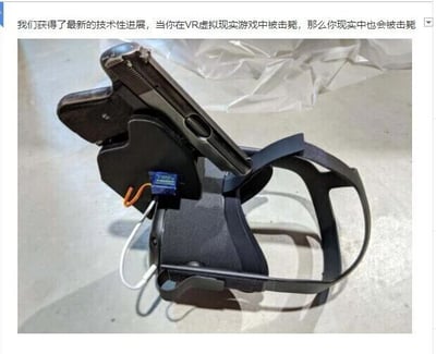 这是一张带有文字加注的原始拍摄静态图，图中展示了一个经过改装的VR头显设备：头显的上方被固定了一把手枪，还加装了一个带有电线的电子元件，看起来像是一个触发装置。图片上方配有文字“我们获得了最新的技术性进展，当你在VR虚拟现实游戏中被击毙，那么你现实中也会被击毙”，这是一个充满黑色幽默的恶搞内容，虚构了一个将VR游戏体验和现实生命安全绑定的恐怖装置，用夸张、荒诞的方式调侃VR游戏的沉浸式体验，实际上这只是一个玩笑性质的改装，并不会真的实现这样危险的功能，仅作为创意恶搞作品存在。