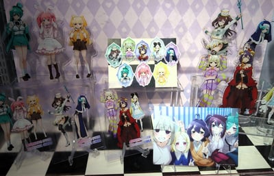 展示了多款动漫《CRITICAL OVER MIRACLE GIRLS》的周边商品，包括多个亚克力角色立牌、徽章和一张团体角色卡片。立牌角色们有着不同颜色的头发和多样的服装，背景是带有心形图案的菱形格子装饰。