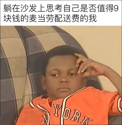 图片上方配有文字“躺在沙发上思考自己是否值得9块钱的麦当劳配送费的我”，下方是一名穿着橙色印有“YORK”字样球衣的男孩，他躺在格子沙发上，单手扶额，表情沉思，生动展现了纠结是否为外卖配送费买单的日常场景。