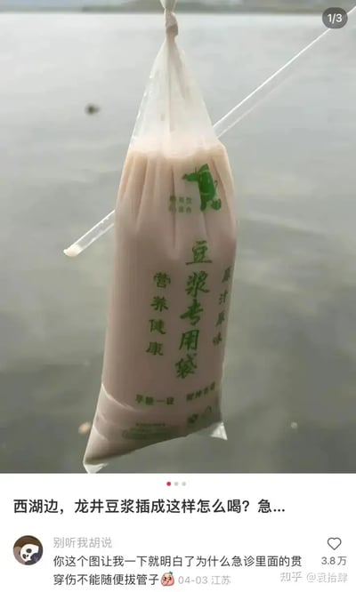 这张图片展示了一袋豆浆吊挂在湖边背景前，吸管插入豆浆袋侧面，极其像医院输液袋，引发搞笑联想。下方评论用医学禁忌做梗，幽默调侃饮用方式，借日常场景和医疗情景产生强烈联想和双关梗。