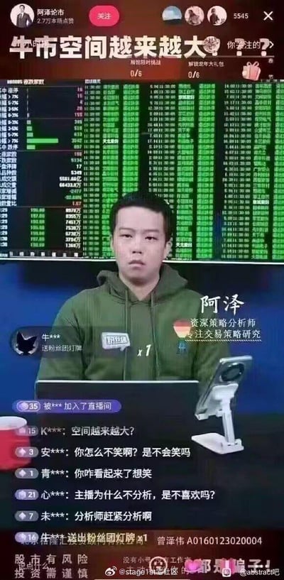 这是一张抖音金融直播的截图，主播阿泽作为资深策略分析师，直播间标题写着“牛市空间越来越大”，但背景的股票行情面板全是绿色的下跌数据，形成强烈的讽刺反差。主播本人坐在镜头前，一脸愁眉苦脸、无奈郁闷的表情，和标题的乐观口号完全不符。弹幕里的观众纷纷调侃主播“怎么不笑”“看起来想笑”，还有观众催促主播分析行情，直播间互动充满戏谑感。图片底部被网友加上了“都是骗子！”的红色文字，再配合“股市有风险 投资需谨慎”的提示，进一步强化了对反向喊口号的金融直播的讽刺意味。