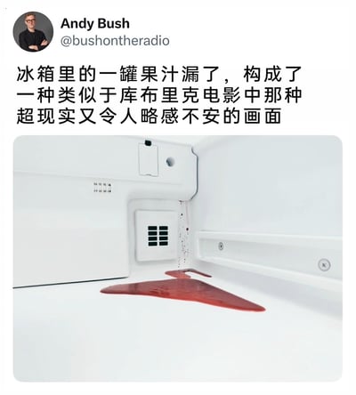 这是一张X（原Twitter）的社交媒体截图，用户Andy Bush分享了自家冰箱内部的实拍画面：一罐红色果汁发生泄漏，红色的液体在洁白的冰箱底板上摊开，还有部分液体从冰箱内壁的缝隙处滴落，形成的痕迹酷似血迹，搭配纯白的背景，营造出一种类似斯坦利·库布里克电影中那种超现实、略带惊悚不安的视觉氛围，配文也直接点明了这一趣味联想。