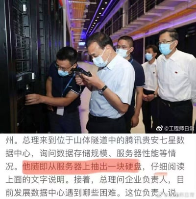 这是一张经过二次创作的恶搞图片，原图为李克强总理视察腾讯贵安七星数据中心的官方场景，被网友通过PS将总理手中的物品替换为手枪，配合下方官方新闻文字“他随即从服务器上抽出一块硬盘，仔细阅读上面的文字说明”形成强烈反差，制造出荒诞搞笑的玩梗效果，是对真实政务视察场景的趣味恶搞。