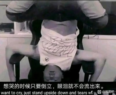 这是一张通过双人配合制造视觉错位效果的搞笑梗图，画面中下方的人露出头部，上方的人将身体置于其头部上方，双腿分开搭在椅子扶手上，搭配的衣物让整体看起来像是一个人倒立在椅子上。图片底部配文“想哭的时候只要倒立，眼泪就不会流出来。”及对应的英文翻译，用这种荒诞的“倒立”姿势来调侃这句文艺的话语，形成强烈的反差感，从而制造出搞笑的效果，图片右下角带有百度贴吧“吊图吧”的水印。