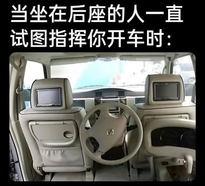 这张梗图展示了一个汽车内部的视角，从后座向前拍摄，画面中央是方向盘和仪表盘。图片上方配有文字：'当坐在后座的人一直试图指挥你开车时:'。图片通过将方向盘朝向后方的视觉错位，幽默地表现了'后座司机'(指在车后座却过度指挥驾驶员的人)试图掌控驾驶的情景。
