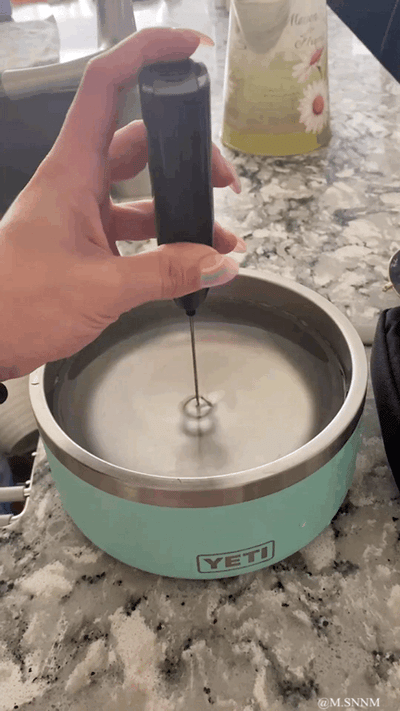 主人先用搅拌工具在YETI品牌的宠物碗中搅出漩涡状的水，随后将碗递给一只花脸狗狗饮用，喝完水的白棕毛色狗狗仿佛被“漩涡”影响，在桌子上疯狂地原地旋转，画面充满反差感，十分搞笑。