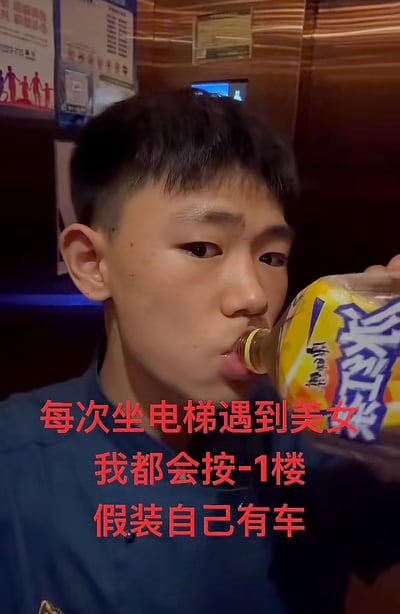 图片中显示一名年轻男子正在喝饮料，背景似乎是在一个室内场所，可能是餐厅或类似的公共空间。男子穿着蓝色上衣，短发，表情看起来比较平静自然。图片上有红色文字覆盖，内容是：'每次坐电梯遇到美女 我都会按-1楼 假装自己有车'，这是一种幽默的自嘲，描述了为了在陌生人面前维持面子而做出的小举动。