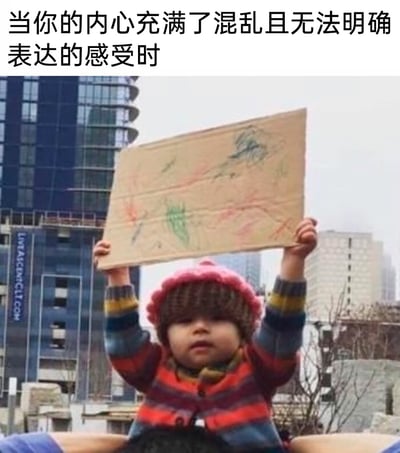 这是一张贴合情绪表达的网络表情包，上方配有文字“当你的内心充满了混乱且无法明确表达的感受时”，下方是一位戴着粉色针织帽、穿着彩色条纹毛衣的小孩，双手高高举着一块画满杂乱无章、毫无逻辑的彩色涂鸦的硬纸板。这张图用非常具象的方式，将人们内心那种繁杂、混乱到无法用语言描述的情绪直观呈现出来，精准戳中人们在情绪理不清、难以言说时的状态，适合在社交场景中用来表达自己当下复杂的心情。