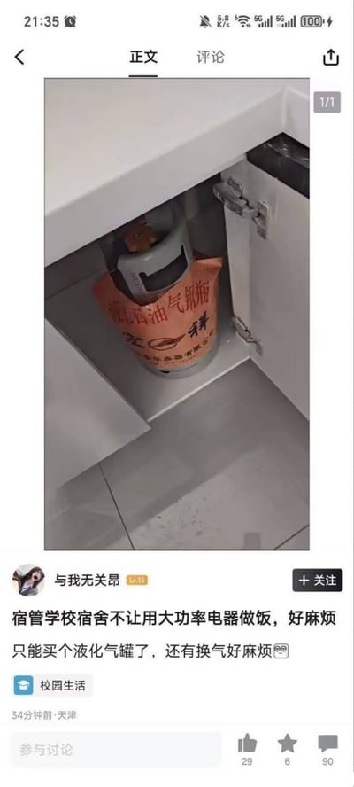 社交媒体截图展示了一则校园生活相关帖子。图片主体为宿舍白色橱柜内部，一个印有“液化石油气钢瓶”字样的橙色包装气罐被放置其中。配文内容反映学生因学校宿舍禁止使用大功率电器做饭，转而购买液化气罐的无奈，同时吐槽换气过程麻烦，并附带苦笑表情😅。发布者账号为“与我无关昂”（等级15），帖子标记“校园生活”话题，发布于天津，34分钟前，当前互动数据显示29点赞、6收藏、90评论。
