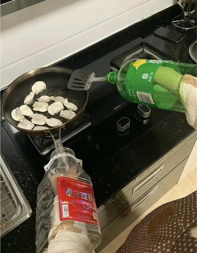 这张图片展示了一种极为搞笑且创新的生活场景：有人在煎饺子，但用来加水的工具却是两个连在一起的大瓶子，巧妙组合出了“自动配水器”，用来精确地往锅里倒水。这种奇葩操作有种DIY和土味智慧的既视感，非常符合网络梗图中“生活无难事，只要想得出”的精神，既让人忍俊不禁，也让人佩服创意。双关/暗示点：画面玩梗“土办法解决问题”，表现生活智慧。