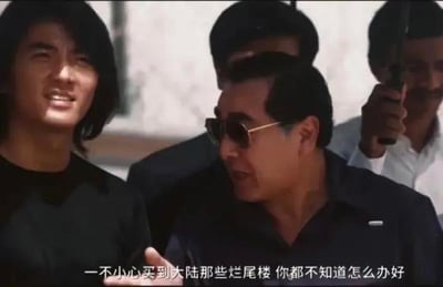 这是一张经过字幕修改的香港电影《古惑仔》系列的剧照截图，画面中左侧是面带笑容的陈浩南（郑伊健 饰），右侧是戴墨镜的基哥（李兆基 饰），他正侧头和陈浩南说话，画面下方的字幕被修改为“一不小心买到大陆那些烂尾楼 你都不知道怎么办好”，用经典影视场景结合房产话题，以调侃的方式表达买到烂尾楼后的无奈与困境，引发相关群体的共鸣。图中没有双关、谐音梗等内容。
