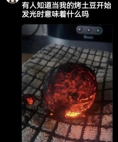 图片展示了一个被严重烤焦的土豆，外皮已经完全碳化变黑，内部呈现出通红的发光状态，仿佛一块烧红的煤炭。图片上方配有文字“有人知道当我的烤土豆开始发光时意味着什么吗”，以幽默的方式呈现了烹饪失败的场景，通过夸张的视觉效果（土豆发光）制造笑点。