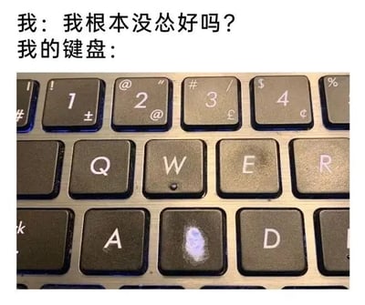 图片上方为文字内容：“我：我根本没怂好吗？我的键盘：”，下方是一张键盘特写照片。键盘上的“S”键（对应中文“怂”的拼音首字母）有明显的白色磨损痕迹，暗示使用者频繁按下该键，与“我没怂”的表述形成幽默反差，通过实物证据调侃口是心非的状态。