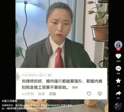 图片中是一位身着黑色西装、白色衬衫和红色领带的律师（晋江刘律师），背景为室内环境，可见绿植、台灯和窗帘。画面下方叠加了一条用户评论，内容为：“刘律师你好，婚内强奸都能算强奸，那婚内媳妇抢走我工资算不算抢劫。” 评论显示来自福建，发布于4小时前，带有“首评”标识。律师表情严肃，双手交叠放在桌上，似在准备回应该法律相关提问。