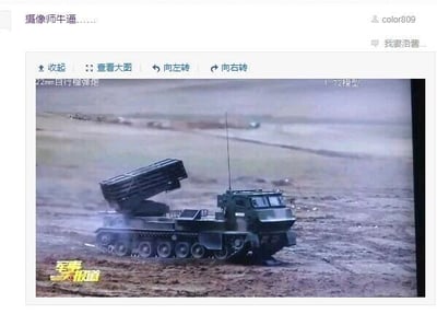 这是一张社交媒体平台的截图，截图内容截取了央视国防军事频道《军事报道》栏目中的一段画面，画面主体是一辆履带式火箭炮停在野外的泥泞地形上，火箭炮的发射装置处于抬起状态。截图顶部显示了用户color809发布的评论“摄像师牛逼……”，还有另一用户的部分评论“我要浩普…”；画面上方标注有“122mm自行榴弹炮”的字样，但该标注与画面中的实际装备不符，实际为火箭炮，同时还有“1:72模型”的标注，画面左下角带有“军事报道”的节目专属水印。用户发布该截图是为了称赞拍摄该军事装备画面的摄像师技术出色。