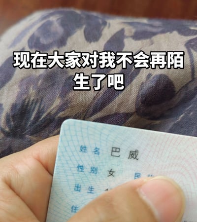 这是一张趣味玩梗的图文混排图片，顶部配有白色粗黑边的文字“现在大家对我不会再陌生了吧”，下方展示了一只手捏着一张身份证的上半部分，身份证上清晰显示姓名为“巴威”、性别为女，其余内容被手指遮挡，背景是带有紫色暗纹的布料。该图借助曾引发公众广泛关注的台风“巴威”的知名度，用同名身份证玩梗，制造出巧妙的笑点。