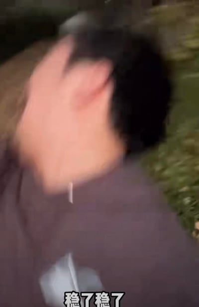 这是一张带有文字加注的视频截图，画面呈现出一位真人的侧脸，由于头部快速晃动，导致人脸部分画面模糊不清，人物身着深色上衣。画面底部配有白色文字“稳了稳了”，画面内容和文字形成反差感——明明画面晃动得很“不稳”，却配文“稳了”，以此制造出搞笑的效果，既可以用来表达事情已经稳妥的真实心态，也可以反讽事情其实并不稳妥，带有玩梗的趣味。