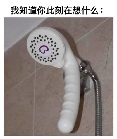图片展示了一个安装在浴室瓷砖墙上的白色淋浴喷头，其手柄设计较为特别。图片上方配有文字"我知道你此刻在想什么："，暗示了淋浴喷头形状可能引发的联想，利用了视觉双关的幽默手法。