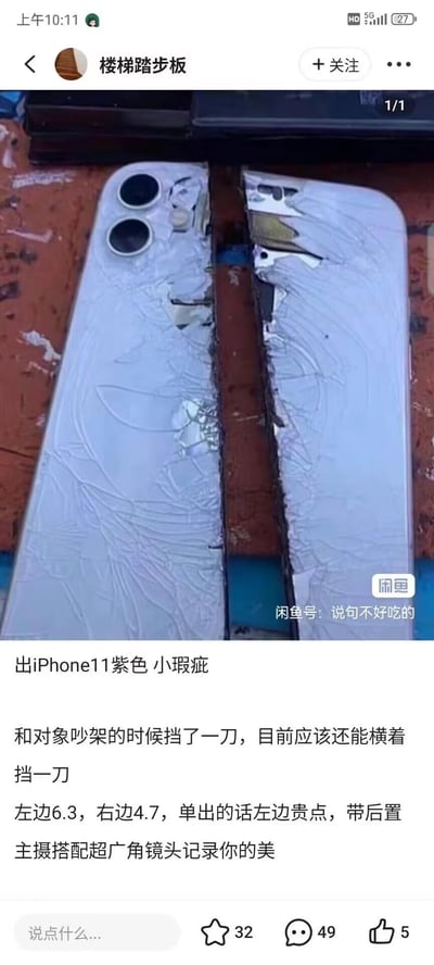 这是一条来自闲鱼平台的搞笑售卖帖，展示了一台被彻底劈成两半的紫色iPhone11，机身后盖完全碎裂，中间的机身内部结构外露。配文以玩梗的方式描述：这是和对象吵架时用来挡刀的“小瑕疵”手机，还调侃目前应该还能横着挡一刀，甚至可以将左右两半单出，左边带后置主摄和超广角镜头，尺寸分别标注为6.3和4.7，用夸张戏谑的语气把彻底损坏的手机包装成可交易的二手商品，制造出荒诞的搞笑效果。