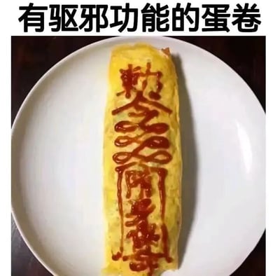 图片上方配有文字“有驱邪功能的蛋卷”，下方是一张实拍图：白色盘子中放着一个黄色的蛋卷，表面用红色酱汁绘制了类似道教符箓的传统文字图案。整体通过将日常食物与驱邪符箓结合，制造出幽默搞笑的效果，属于创意美食梗图。