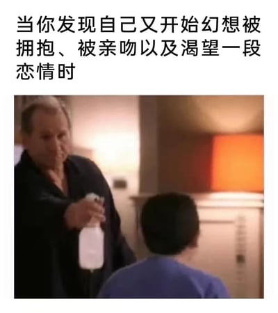 图片上方配有文字“当你发现自己又开始幻想被拥抱、被亲吻以及渴望一段恋情时”，下方是一位穿着深色浴袍的中年男性手持透明喷雾瓶，正对着一个背对镜头、穿着蓝色衣服的小孩头部喷洒的场景。通过将浪漫幻想的内心活动与“被喷雾清醒”的幽默画面结合，形成强烈反差，调侃人们在产生恋爱渴望时的“不切实际”，用夸张的“物理干预”方式表达对这种情绪的自嘲。
