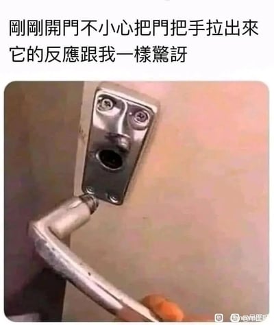 这是一张充满趣味的搞笑梗图，画面中一只手将金属门把手从门上扯了下来，门锁留在门上的底座部分，其螺丝孔和中心的孔洞恰好组合成了一张瞪大双眼、张开嘴巴的惊讶人脸，与被扯出的门把手搭配，仿佛这个门把手也因为意外脱离门体而露出了惊讶的神情。图上方的文字“刚刚开门不小心把门把手拉出来 它的反应跟我一样惊讶”，用拟人的手法将这个意外场景赋予了情绪，放大了荒诞搞笑的效果，把日常的小意外转化为让人会心一笑的趣味内容。