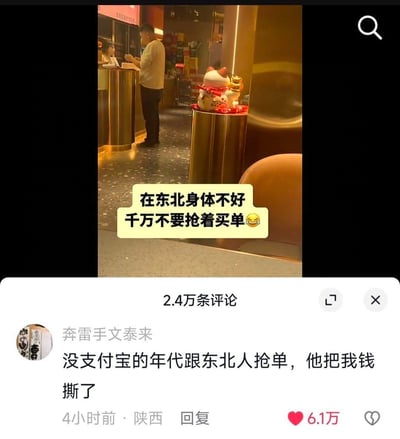 社交媒体截图展示餐厅场景，一名男子正在柜台前疑似结账，金色立柱上摆放着戴红绸的招财猫摆件。画面中央黄色对话框文字调侃：'在东北身体不好千万不要抢着买单😂'，下方显示2.4万条评论区，热评'奔雷手文泰来'分享趣闻：'没支付宝的年代跟东北人抢单，他把我钱撕了'，幽默夸张地表现东北人抢着买单的热情文化。
