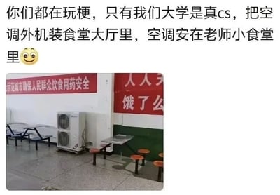 这张图为图文混排内容，上方配文吐槽发帖人所在的大学存在区别对待师生的不合理安排：网络上大家都在玩相关“cs”梗，而自己学校是现实版的离谱操作，将空调外机安装在学生使用的公共食堂大厅内，空调内机则安装在仅对教师开放的小食堂中，会导致学生用餐的大厅区域被空调外机散发的热量加热，温度升高，就餐体验极差。下方配图为实拍的学校食堂大厅场景，墙角处确实摆放着一台空调外机，周围是供学生使用的连体餐桌座椅，墙面还张贴有保障饮食用药安全的红色宣传横幅。