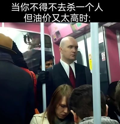 图片上方配有文字“当你不得不去杀一个人但油价又太高时:”，下方是地铁车厢内的场景。一名穿着黑色西装、系红色领带的 bald 男子表情严肃地扶着地铁扶手，周围有其他乘客。通过将“杀手执行任务”的严肃设定与“因油价高改乘地铁”的日常场景结合，形成强烈反差，营造出幽默搞笑的效果。