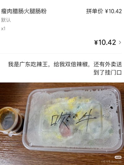 图片上半部分为外卖订单截图，显示商品为“瘦肉腊肠火腿肠粉”，拼单价10.42元，用户备注“我是广东吃辣王，给我双倍辣椒，还有外卖送到了挂门口”。下半部分为实拍图，透明外卖盒盖有水雾，上面用黑色马克笔写着“吹牛”二字，旁边放着一小杯酱料。整体通过订单备注与店家手写回应形成幽默对比，展现外卖交流中的趣味场景。