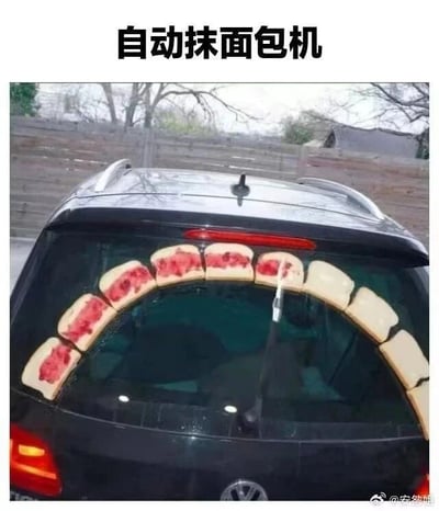 这是一张充满创意的搞笑静态单图，画面主体是一辆黑色汽车的尾部，后挡风玻璃上沿着玻璃的弧度粘贴了一排切片面包，其中左侧的几片面包上有类似红色果酱的涂抹物，汽车的后雨刮器恰好处于面包排列的区域。图片顶部配有文字“自动抹面包机”，利用后雨刮器摆动的动作，将其联想成给面包抹酱的装置，把汽车后窗场景和日常的抹面包行为进行错位结合，营造出荒诞又有趣的搞笑效果，通过日常物品的新奇搭配，制造出反差感满满的创意笑点。