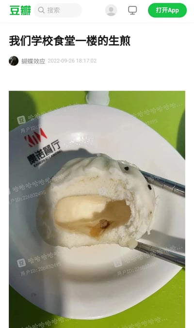 这是豆瓣用户“蝴蝶效应”发布的一条吐槽校园食堂的内容，标题为“我们学校食堂一楼的生煎”，配图是一个被筷子夹着的、咬开的生煎，这个生煎的面皮厚实，内部只有极少的一点馅料，与“生煎”应有的饱满馅料形成强烈反差，以此吐槽食堂的生煎分量不足、馅料过少。图片上带有多处半透明的“哈哈哈哈哈哈哈哈...”文字水印和“用户ID:226832495”水印，还有左上角的“豆”字标识；盛放生煎的白色盘子上印有“康诺餐厅 KANGNUO CANFING”的红色与黑色标识，背景是绿色的桌面。