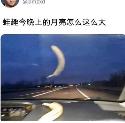 图片上方显示社交媒体用户@jamzxd的发文“蛙趣今晚上的月亮怎么这么大”，下方是一张从汽车内部拍摄的夜间公路照片。照片中天空出现一个巨大的弯形物体，形似香蕉，同时汽车仪表盘上也放着一根香蕉，通过视觉错位让香蕉看起来像超大月亮，形成“把香蕉误认为月亮”的搞笑误会。