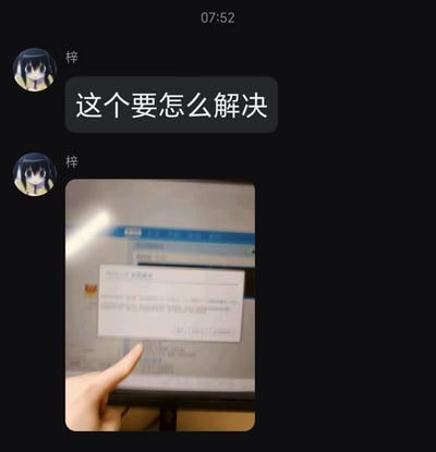 一张聊天记录截图，显示联系人“梓”（使用动漫头像）在07:52发送两条消息。第一条消息为文字“这个要怎么解决”，第二条消息为一张照片：照片中是电脑屏幕显示的错误弹窗，一只手的食指正指向该弹窗，似乎在示意需要解决的问题。