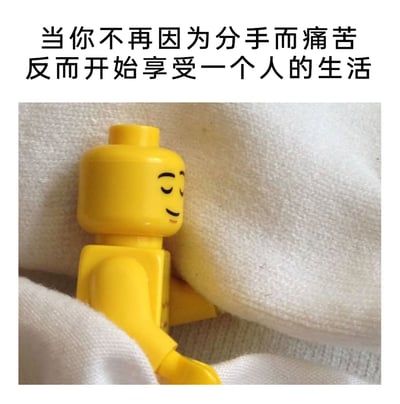 这是一张顶配底文类静态梗图，上方配有文字“当你不再因为分手而痛苦，反而开始享受一个人的生活”，下方是一个黄色乐高经典人偶，它双眼闭合、嘴角上扬，一脸满足惬意地窝在柔软的白色布料中，姿态放松，仿佛正舒适地休息。图片用可爱的乐高形象生动具象化了人们摆脱分手痛苦后，沉浸在独处生活里的自在与治愈感，传递出单身生活的美好情绪。